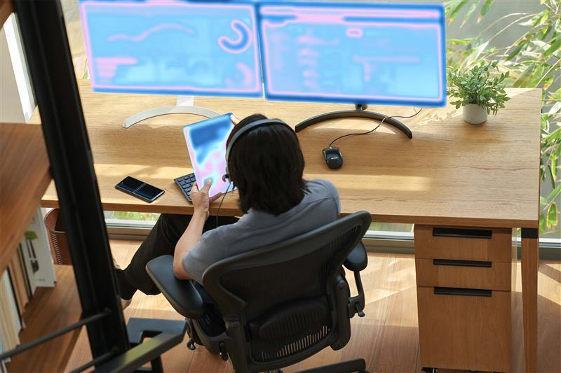 Developer working with AI tools at desk with dual monitors